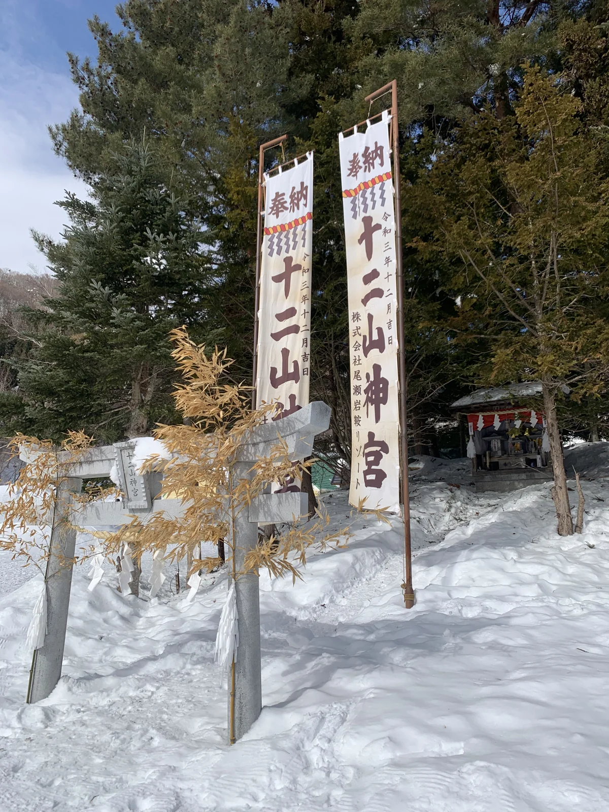 尾瀨岩鞍十二山神宮的旗幟與雪中樹林